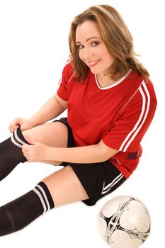 Young woman in soccer uniform sitting on isolated