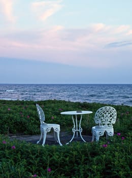 Beautiful romantic setting for two by the sea - table and two chairs on the beach
