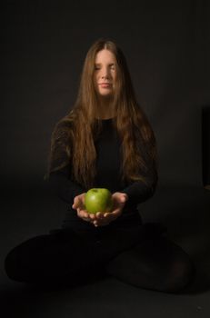 The portrait of a woman with a green apple in her hands