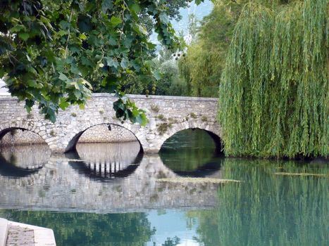 Old stone bridge reflection in the river