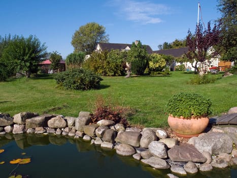 Beautiful summer backyard garden with water fish pond