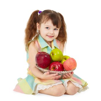 A beautiful girl sitting on a white floor with a plate of ripe fruit