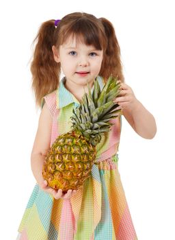 Child holding a large ripe pineapple isolated on a white background