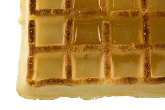a detail of Belgian waffle with maple syrup isolated on white
