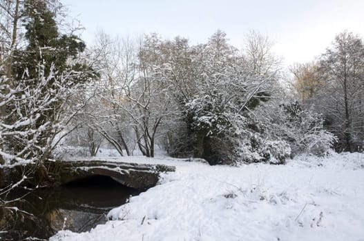 A footpath over a bridge  covered in snow