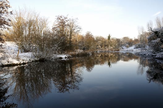 A view of a lake in winter with snow