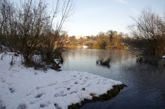 A view of a lake in winter with snow