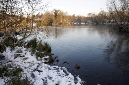 A view of a lake in winter with snow