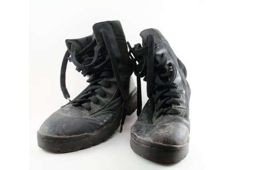 A pair of black, worn combat boots isolated on white.