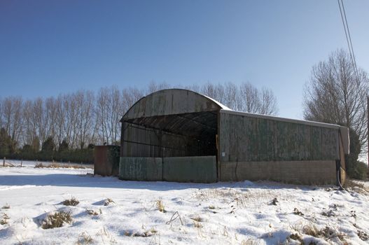 A metal agricultural barn in the snow