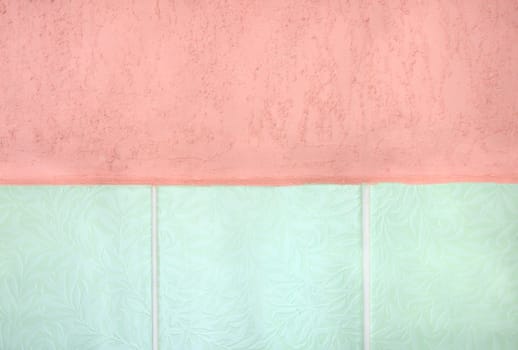 Pink stucco and green tiled wall. 