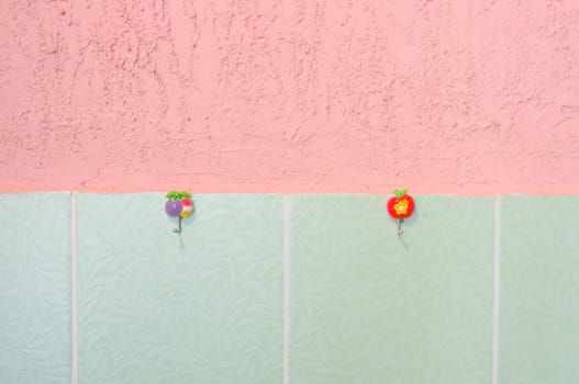 Pink stucco and green tiled wall. With hooks.