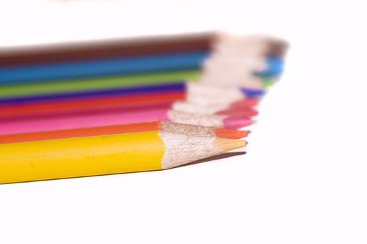 Assortment of coloured pencils with shadow on white background