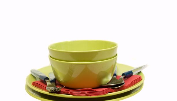 green dinner setting and red napkins on white background