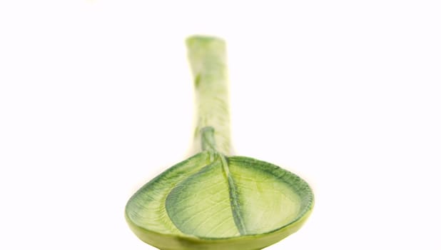 big ceramics green spoon on white background