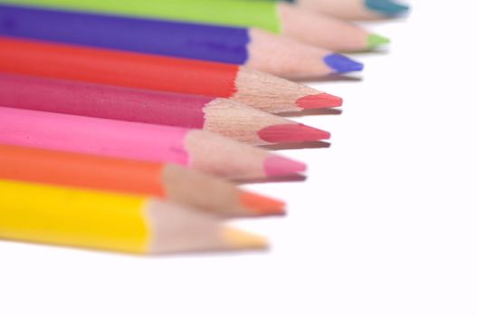 Assortment of coloured pencils with shadow on white background