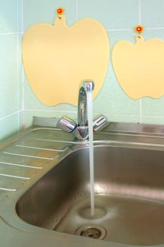 Kitchen sink with water runs from the tap.