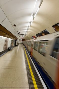Underground train arriving at Charing Cross station in London. Motion blur.