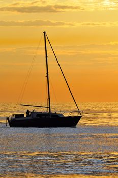 Silhouette of a boat navigating on the sea at the sunset