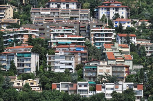 Many buildings on a green hill