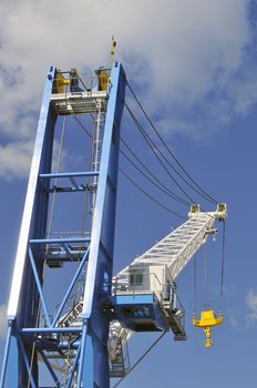 Big crane with yellow hook against a blue sky