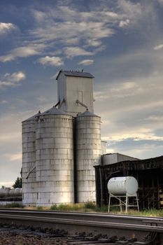 Old grain elevator, water tank and shack next to railroad tracks in Colorado