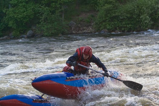 sportsmen on the blue catamaran in the rapid 
