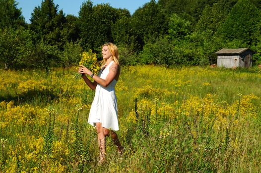blond woman in white dress on a meadow