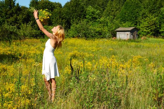 blond woman in white dress on a meadow