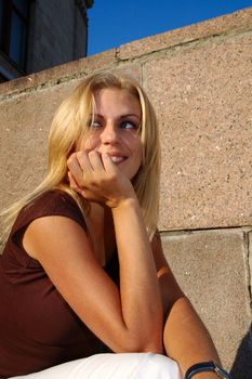 Smiling blond woman against red granite