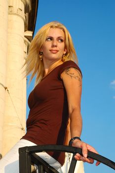 Smiling blond woman with fly-away hair against blue sky