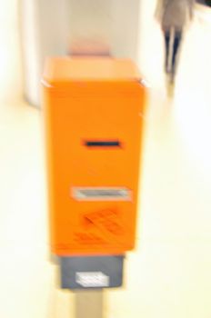 Overexposed ticket machine on train platform with person moving in the background