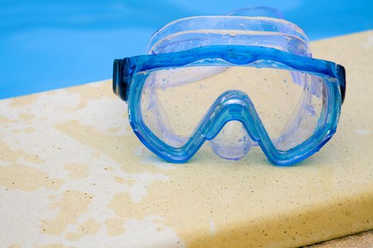 Diving mask on the bank of a swimming pool.
