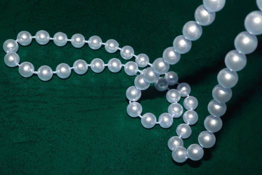string of pearls against a dark green background
