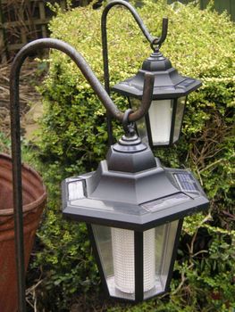 two solar garden lights hung on frames 