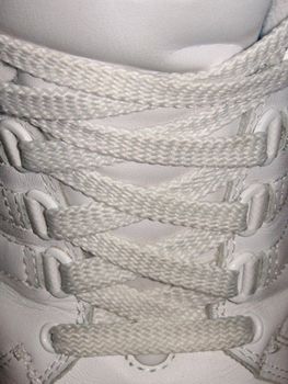 shoe-laces threaded in the eyelets of a training shoe
