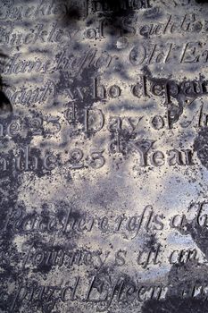 A section of an old distressed and eroded gravestone from the 1600's.  Background image for Halloween or anything spooky.  Scanned film.
