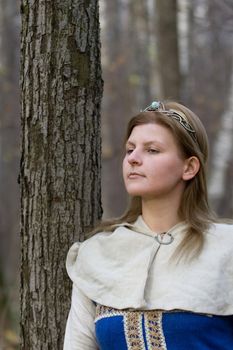 Portrait of the romantic girl in autumn forest
