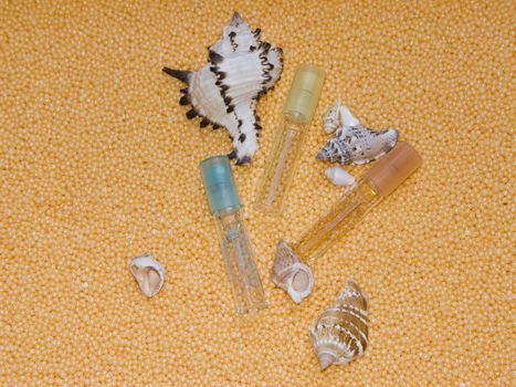 The image of bottles of perfume and cockleshells on a yellow background
