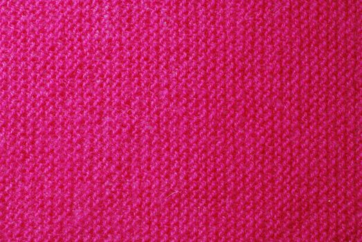 Pink knitted material background or texture close-up.