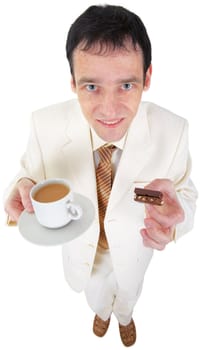 Funny young man is drinking coffee with sweets on white