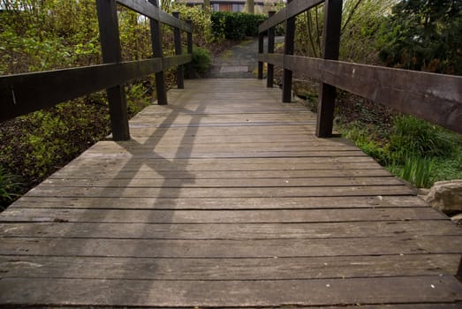 Wooden Bridge leading to an unknown path, focus on the middle of the bridge