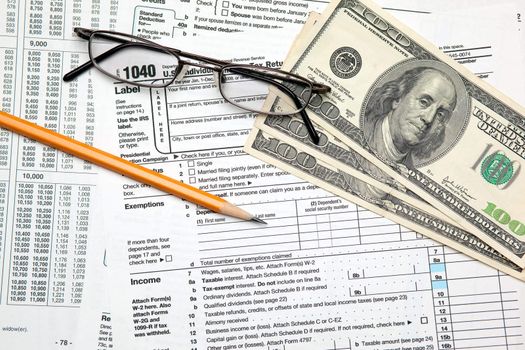 Tax time - Closeup of U.S. 1040 tax return with pencil and glasses