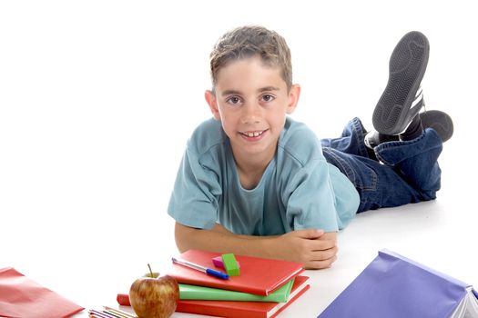 a boy laying on the ground, with his schoolstuff