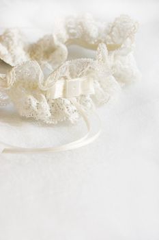 Wedding garter on white satin fabric