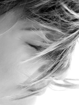 Detail portrait of a woman in high key with focus on strands of hair