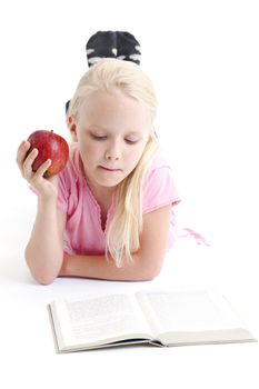 Young girl reading a book on the floor