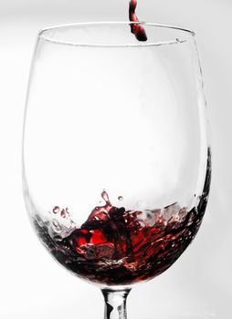 Red Merlot wine pouring into a wine glass