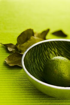 Lime with kafir leaves on the green table