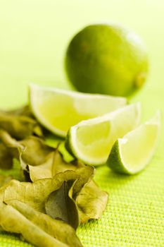 Lime with kafir leaves on the green table (shallow dof)